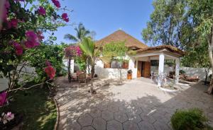 a house with a patio and a tree at Villa My Moon - en bord de mer au coeur de Saly in Saly Portudal