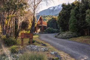 una casa al lado de una carretera con un cartel en Totara Lodge - Unwind, Relax & Enjoy - Mt Lyford, en Mt Lyford