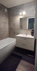bagno con lavandino, vasca e specchio di Appartement Disneyland Paris a Bussy-Saint-Georges