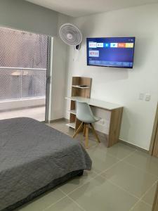 a bedroom with a bed and a desk and a tv at Marina Club Piso 8 in Cartagena de Indias
