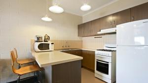 a kitchen with a white refrigerator and a microwave at Alpine Heights 04 in Mount Hotham +6 photos