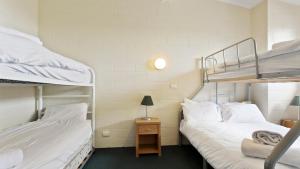 two bunk beds in a room with a table and a lamp at Alpine Heights 04 in Mount Hotham