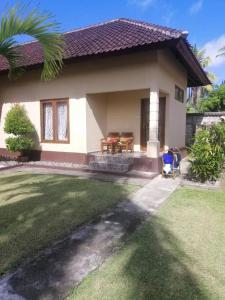a small house with a lawn in front of it at Yuli's Homestay in Kuta Lombok