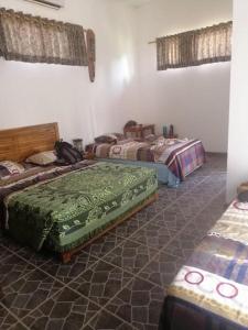 a room with three beds in a room at Yuli's Homestay in Kuta Lombok