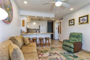 a living room with a couch and a kitchen at Condo On the Ocean, Lagoon and Garden - Hale Kona Kai 411 by Casago Kona in Kailua-Kona