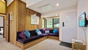 a living room with a purple couch with pillows at Snowtel 4 in Mount Hotham