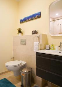 une salle de bain avec toilettes, lavabo et miroir dans l'établissement Elegant apartment in eagle beach levent, à Palm-Eagle Beach