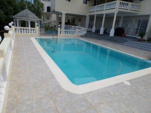 - une piscine en face d'une maison dans l'établissement The Royal Kensington Villa 4, à Montego Bay