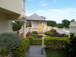 une maison avec une clôture blanche et une terrasse couverte dans l'établissement The Royal Kensington Villa 4, à Montego Bay