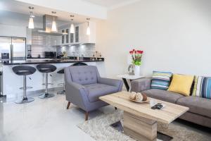 una sala de estar con un sofá y una mesa en Spectacular apartment in tierra del sol golf course, en Palm-Eagle Beach