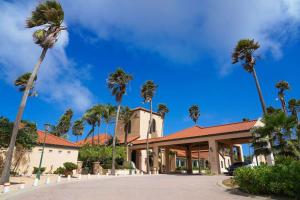 Un edificio con palmeras delante. en Spectacular apartment in tierra del sol golf course, en Palm-Eagle Beach