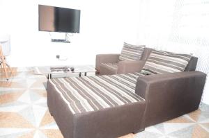 a living room with a couch and a tv at LES RÉSIDENCES SOHA in Cotonou