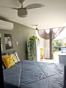a bedroom with a blue bed and a large window at Tiny House Paraiso Minicasas Com Hidromassagem in Pouso Alegre