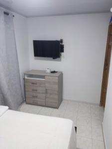 a bedroom with a bed and a tv on a wall at San San Andrés Magic House 0 by BBBSAI in Buenavista