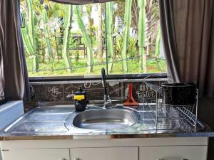 a sink in a kitchen with a window at Tiny House Paraiso Minicasas Com Hidromassagem in Pouso Alegre