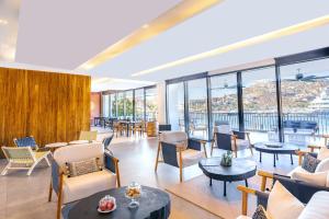 a lobby with tables and chairs and windows at Breathless Cabo San Lucas - Adults Only in Cabo San Lucas