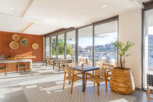a dining room with tables and chairs and windows at Breathless Cabo San Lucas - Adults Only in Cabo San Lucas