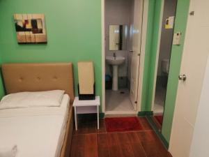 een slaapkamer met een bed en een badkamer met een wastafel bij ANNELENA INN in Manilla