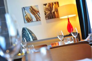 a table with wine glasses and a lamp on it at The White Lion Hotel in Aldeburgh