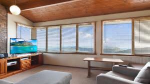 sala de estar con sofá y TV y algunas ventanas en Lawlers 34, en Monte Hotham