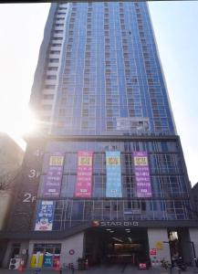un edificio alto con letreros en la parte delantera en Mi Stay - StarBnB branch, en Daegu