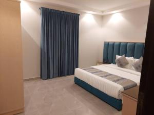 a bedroom with a large bed with a blue headboard at غرفة وصالة فاخرة حي السلامة in Jeddah
