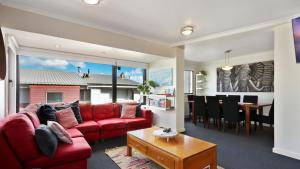 a living room with a red couch and a dining room at Lawlers 30 in Mount Hotham