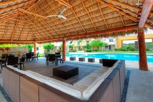 a pavilion with a table and chairs and a pool at Casa M in Bucerías
