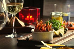 a table with a plate of food and a glass of wine at The White Lion Hotel in Aldeburgh