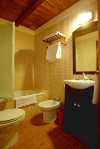 a bathroom with a toilet and a sink and a tub at El Faixero Tradicional in Cinctorres