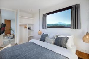 a bedroom with a large bed and a large window at Telescope Villas Lombok in Kuta Lombok