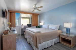 カイルア・コナにあるOceanfront Condo Stunning Views and Pool - Hale Kona Kai 407 by Casago Konaの天井ファン付きの大きなベッドのある寝室