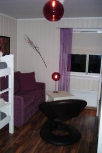 レーロースにあるRørosvidda Hotellの紫色のソファとテーブル付きのリビングルーム
