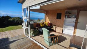 een woonkamer met een bank en een stoel op een veranda bij Spectacular Moana Views in Riverton