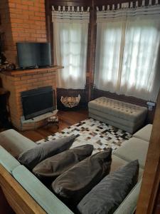 ein Wohnzimmer mit einem Sofa und einem Kamin in der Unterkunft Casa de campo em Monte Verde , linda vista para montanhas in Monte Verde