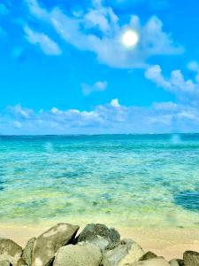 a view of the ocean with rocks on the beach at Breezy Beachfront Bali-Style Haven 180 Degree OceanView in Hauula