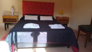 a bedroom with a large bed with two towels on it at 9 de julio in Villa Mercedes