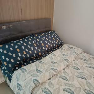 a bed with a headboard and pillows on it at 1 bedroom unit condo in Manila