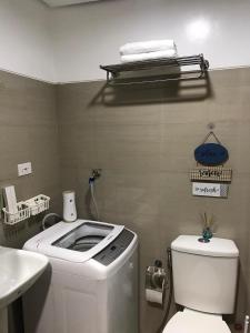 a bathroom with a washer and a toilet and a sink at 1 bedroom unit condo in Manila