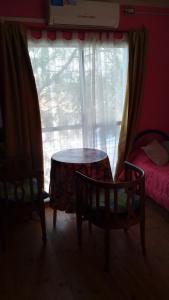 ein Raum mit einem Tisch und zwei Stühlen und einem Fenster in der Unterkunft 9 de julio in Villa Mercedes + 6 Fotos