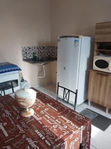 a kitchen with a refrigerator and a table and a rug at Parque Jockey Campos in Campos dos Goytacazes