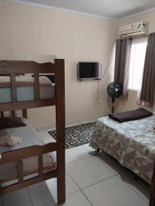 a bedroom with two bunk beds and a television at Parque Jockey Campos in Campos dos Goytacazes