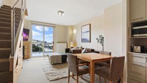 a dining room and living room with a table and chairs at Chalet Hotham 13 in Mount Hotham