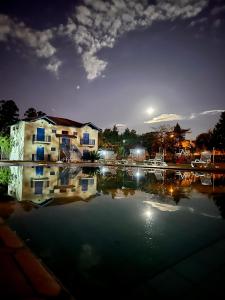 a reflection of a building in the water at night at Stallage Hotel in São Pedro