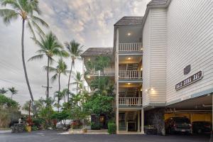 カイルア・コナにあるTrue and Absolute Oceanfront Condo Breathtaking Views From The Lanai - Hale Kona Kai 402 by Casago Konaの前にヤシの木がある建物