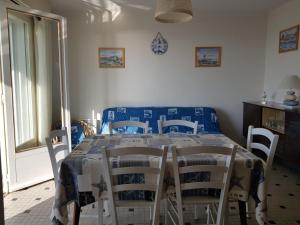 ein Esszimmer mit Tisch und Stühlen in der Unterkunft Notre-Dame-de-Monts (85) - Appartement de vacances 55m² environ - 5 personnes - FR-1-540-147 in Notre-Dame-de-Monts