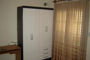 a bedroom with a white cabinet and a curtain at Departamentos Donovan in Resistencia