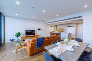 una sala de estar con un sofá y una mesa en Multi Million River View 3BD Penthouse at SouthBank, en Brisbane