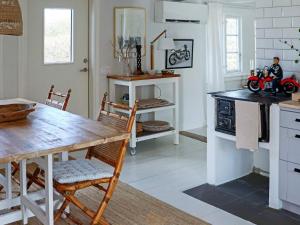 uma cozinha com uma mesa de madeira e uma sala de jantar em Holiday home BÅSTAD em Båstad