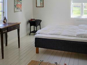 um quarto com uma cama, uma secretária e uma mesa em Holiday home BÅSTAD em Båstad